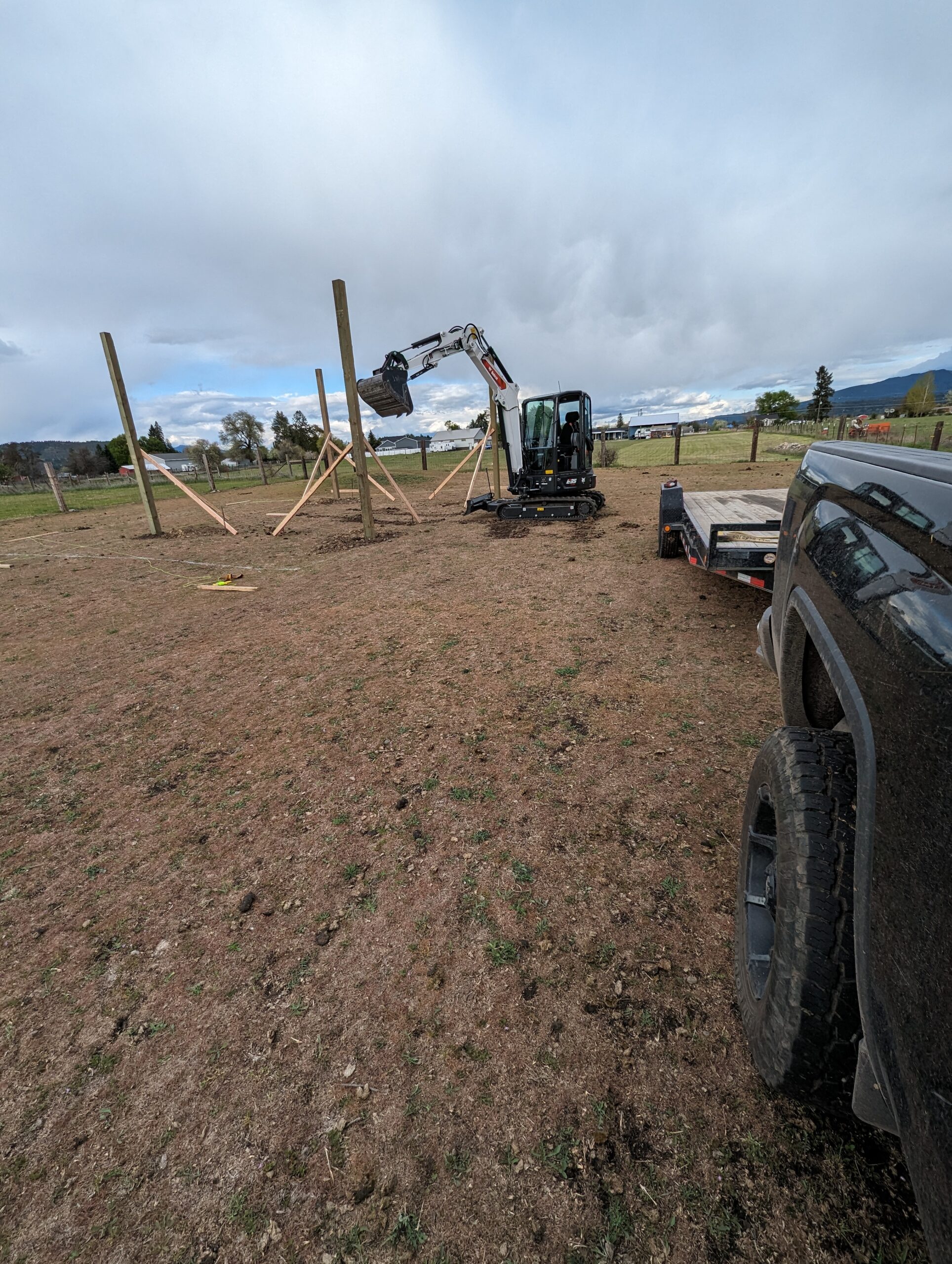 Mini excavator grading a pole barn pad on a rural property near Spokane, Washington